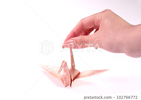 Origami crane and woman's hand Origami crane and woman's hand 102766772