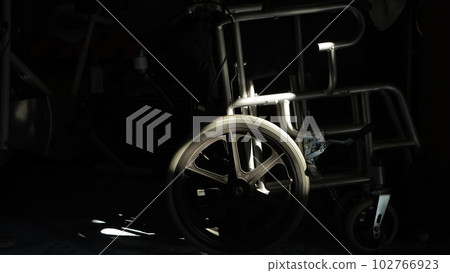 wheelchair with the shadow of the setting sun 102766923