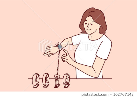 Woman tries on smart watch or fitness bracelet, wanting to choose device for playing sports Woman tries on smart watch or fitness bracelet, wanting to choose device for playing sports 102767142