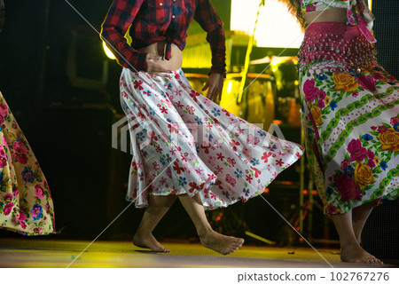 Young dancer woman barefoot in gypsy dress dancing on stage 102767276