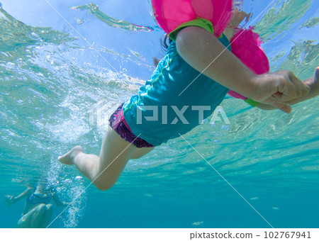 Underwater view of baby girl swimming in sea 102767941