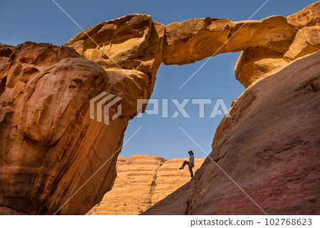 Tourist posing at Um Fruth rock bridge 102768623