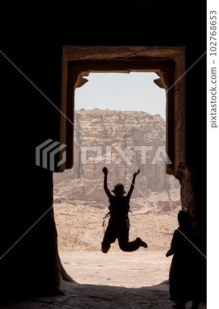 Silhouette of a traveler woman jumping in Petra, Jordan 102768653