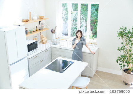 A young woman drinking coffee in the kitchen A young woman drinking coffee in the kitchen 102769000