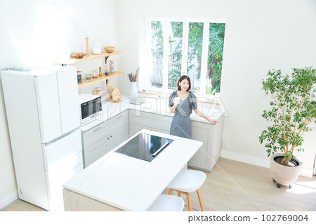 A young woman drinking coffee in the kitchen A young woman drinking coffee in the kitchen 102769004