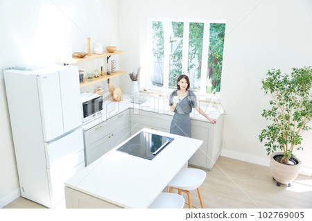 A young woman drinking coffee in the kitchen A young woman drinking coffee in the kitchen 102769005