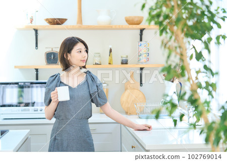 一個少婦飲用的咖啡在廚房裡 102769014