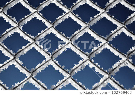 Metallic net covered with hoarfrost. Extreme cold weather concept 102769463