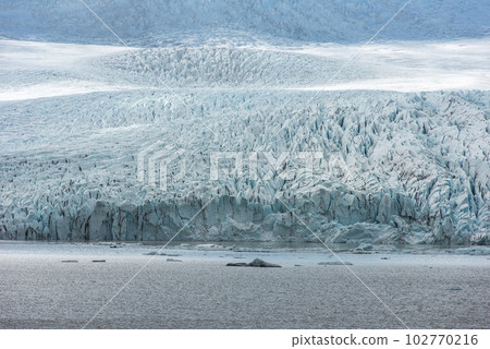 Floating icebergs melting in Fjallsarlon glacier lake, Iceland 102770216