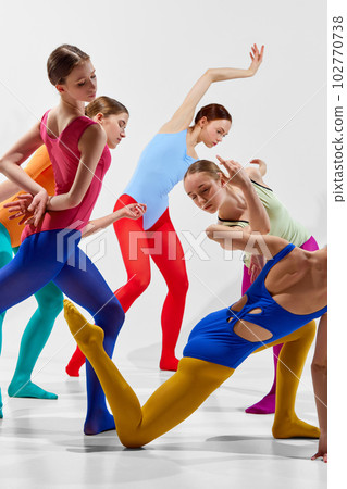 Cropped, close-up image of young girl. ballerinas in bright, multicolored tights and bodysuits dancing over grey background Cropped, close-up image of young girl. ballerinas in bright, multicolored tights and bodysuits dancing over grey background 102770738