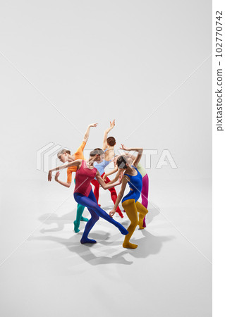 Expressive, artistic female ballet dancers in bright, multicolored clothes performing, dancing against grey studio background Expressive, artistic female ballet dancers in bright, multicolored clothes performing, dancing against grey studio background 102770742