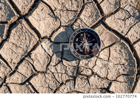 Compass and navigation background on dry soil, top-view 102770774