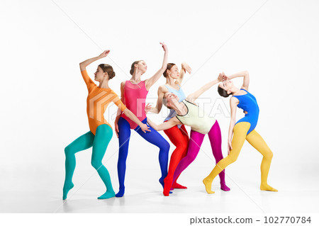Expressive dance. Stylish, young girls, ballet dancers in bright clothes making performance against grey studio background 102770784