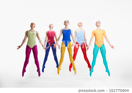 Tender young girls, ballerinas in colorful, brights tights and bodysuits dancing against grey studio background Tender young girls, ballerinas in colorful, brights tights and bodysuits dancing against grey studio background 102770804