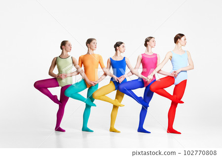 Young beautiful girls, professional ballet dancer in colorful bodysuits and tights standing in dancing position against grey studio background 102770808