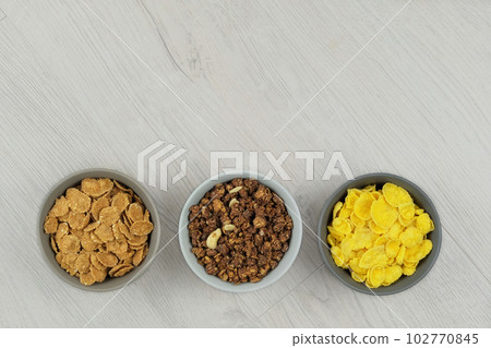 Breakfast cereals in bowls on a light wooden background. Fast food. Top view. Space for text. 102770845