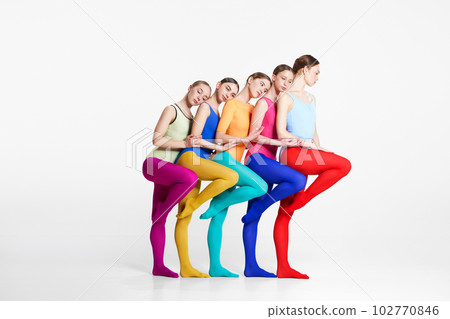 Friendship. Young girls, ballerinas in colorful bodysuits and tights standing closely to each other against grey studio background Friendship. Young girls, ballerinas in colorful bodysuits and tights standing closely to each other against grey studio background 102770846
