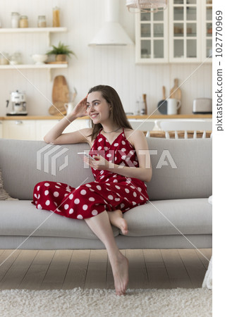 Cheerful dreamy beautiful adult girl holding cellphone Cheerful dreamy beautiful adult girl holding cellphone 102770969