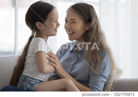 Cheerful excited mother holding little kid in arms on lap Cheerful excited mother holding little kid in arms on lap 102770971