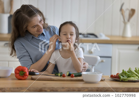 Happy mom and sweet little girl preparing salad Happy mom and sweet little girl preparing salad 102770998