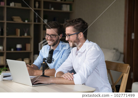 Cheerful twin men sitting at laptop and studio microphone 102771499