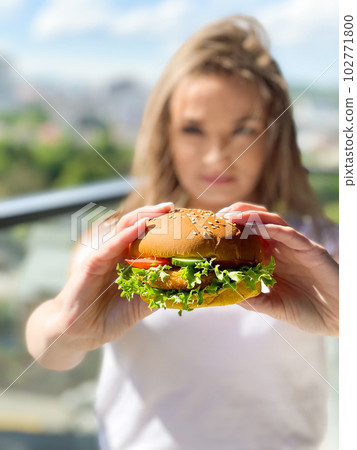 Young woman eating hamburger woman eating junk food 102771800
