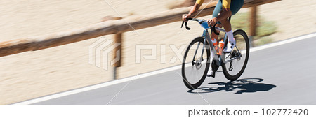 Road bike cyclist man cycling, athlete on a race cycle. Panning technique used 102772420