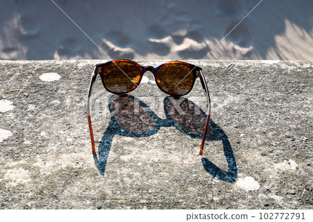 Sunglasses on a Seaside Beach Wall in Spring Sunshine 102772791