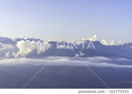 beautiful view of the mountains of the Caucasus range in white clouds at sunset, natural background landscape blue sky 102775503