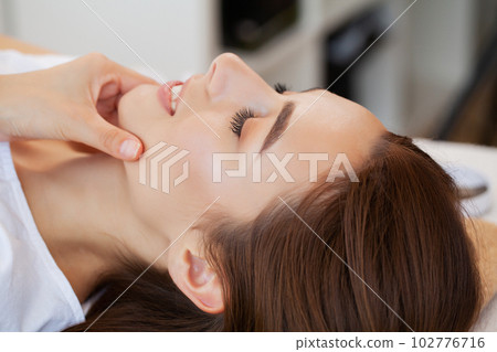 Closeup face woman having facial massage at spa. 102776716