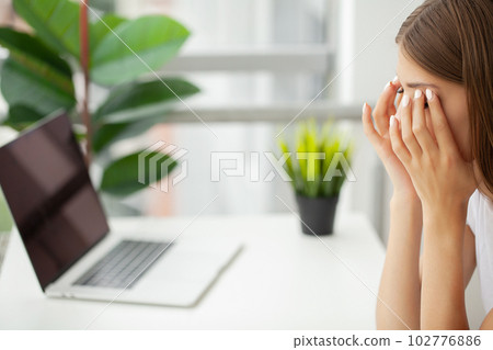 Portrait of tired young business woman with laptop computer Portrait of tired young business woman with laptop computer 102776886