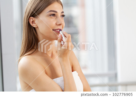 ng beautiful woman making make-up near mirror 102776905
