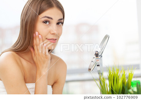 ng beautiful woman making make-up near mirror ng beautiful woman making make-up near mirror 102776909