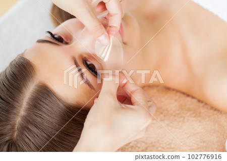Hands of cosmetologist making manual relaxing rejuvenating facial massage for woman in beauty salon Hands of cosmetologist making manual relaxing rejuvenating facial massage for woman in beauty salon 102776916
