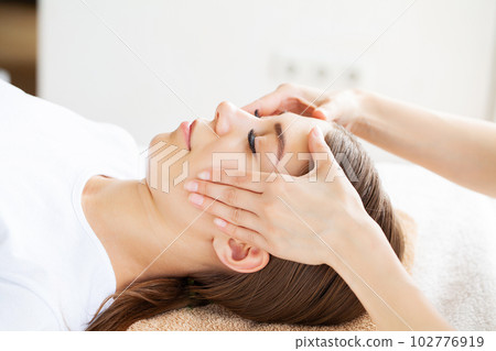 Close-up of young woman getting spa massage treatment at beauty spa salon. Close-up of young woman getting spa massage treatment at beauty spa salon. 102776919