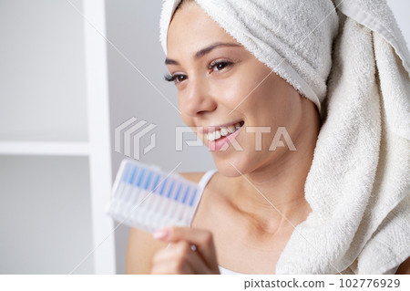 The woman uses brushes to clean the interdental spaces The woman uses brushes to clean the interdental spaces 102776929