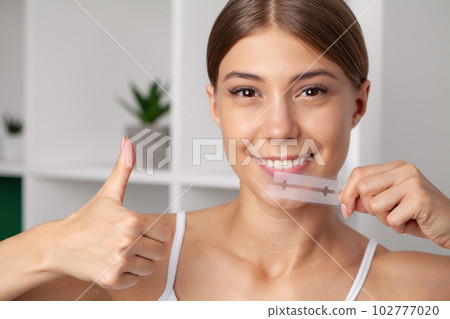 Teeth Whitening, Beautiful Smiling Woman Holding Whitening Strip. Teeth Whitening, Beautiful Smiling Woman Holding Whitening Strip. 102777020
