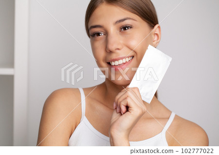 Teeth Whitening, Beautiful Smiling Woman Holding Whitening Strip. Teeth Whitening, Beautiful Smiling Woman Holding Whitening Strip. 102777022
