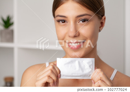 Teeth Whitening, Beautiful Smiling Woman Holding Whitening Strip. Teeth Whitening, Beautiful Smiling Woman Holding Whitening Strip. 102777024