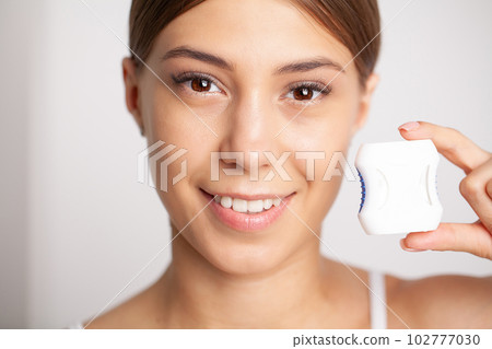 Woman using dental floss for cleaning her teeth Woman using dental floss for cleaning her teeth 102777030