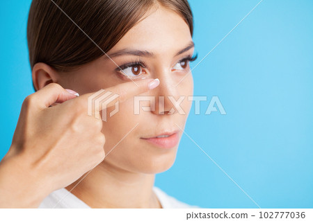 Smiling woman with contact eye lenses and container in hand 102777036