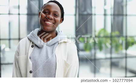 Smiling young woman standing and looking at the camera. Smiling young woman standing and looking at the camera. 102777094