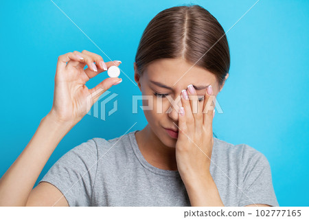 Woman holding pill and glass water, taking medicine from headache, stomach pain or taking vitamins Woman holding pill and glass water, taking medicine from headache, stomach pain or taking vitamins 102777165