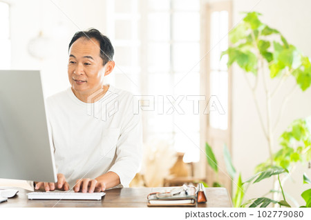 顯示器前穿著便裝工作的中年男子 102779080