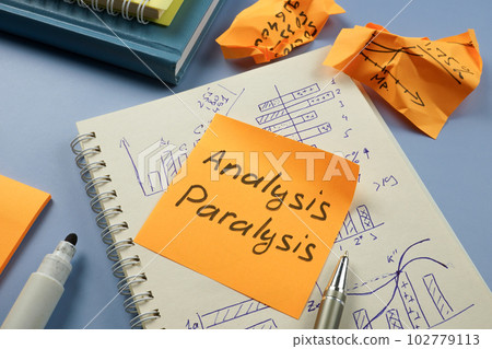 Analysis paralysis concept. Notepad with graphs and a sticker with the inscription. 102779113