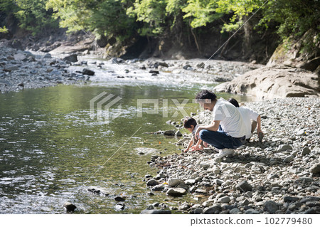 Image of parent-child leisure, outdoors, and playing in the river during summer vacation; copy space available 102779480