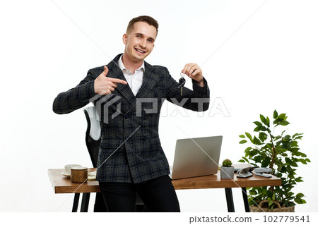 Successful caucasian cheerful man holding a key Successful caucasian cheerful man holding a key 102779541
