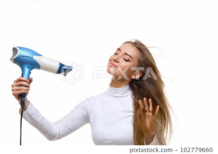 Portrait of attractive cheerful girl drying long hair 102779660