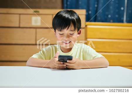 Elementary school boy watching videos on smartphone 102780216