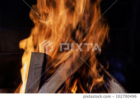 Firewood burning in traditional rural fireplace an winter time Firewood burning in traditional rural fireplace an winter time 102780496
